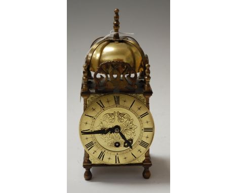 A brass cased lantern clock, in the 17th century style, having a strapwork bell top within pierced spandrels, the brass chapt