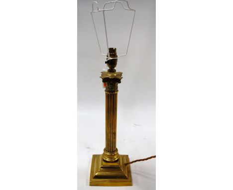 An early 20th century brass table lamp base having Corinthian capital on fluted column and stepped square base, with shade, h