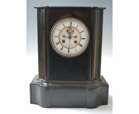 A large late 19th century black slate cased mantel clock, of serpentine form, having enamelled chapter ring with Roman numera