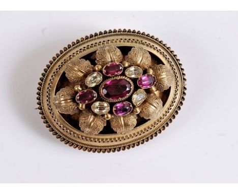 A garnet and citrine brooch, the oval brooch set with an oval garnet surrounded by smaller alternating garnets and citrines i