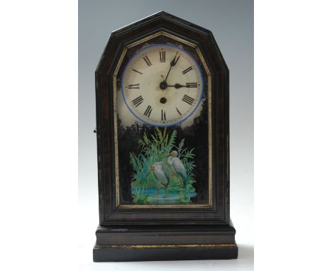 A late 19th century ebonised cased mantel clock, having a painted wooden dial with Roman numerals, enclosed by a glazed door 