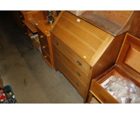 A light oak bureau fitted three drawers