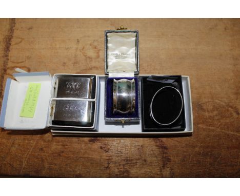 A cased pair of silver napkin rings, Sheffield 1944 with initial and date for 29.6.45, another silver napkin ring and a plate