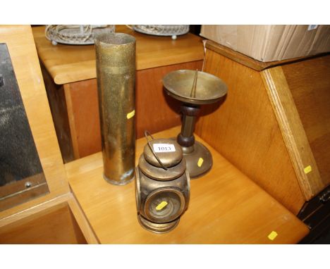 A vintage brass shell case, a brass pricket candle stick and a small lamp