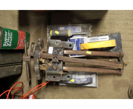 A Woden bench vice and three plasterers trowels 