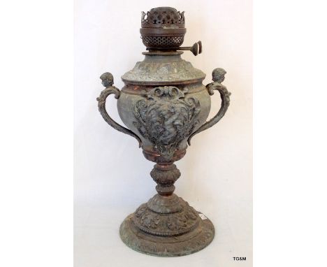 A Victorian cast metal oil lamp with cherub handles