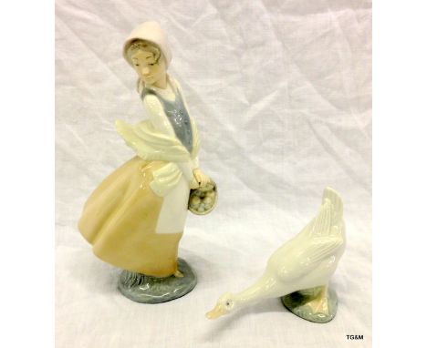 A Nao porcelain figure of a girl holding a basket with another figure of a goose figure 25cm high