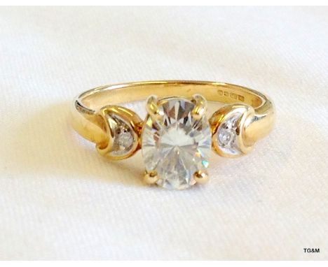 A gold ring set a large oval Moissanite (tests as a diamond) with diamond shoulders