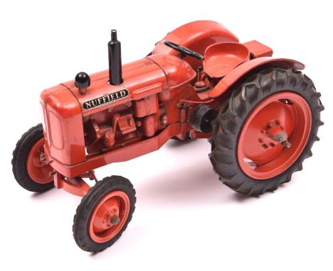 A model of a Nuffield Universal tractor by Denzil Skinner Co. Ltd. Example in dark orange. QGC-GC, paint chipping overall, wi