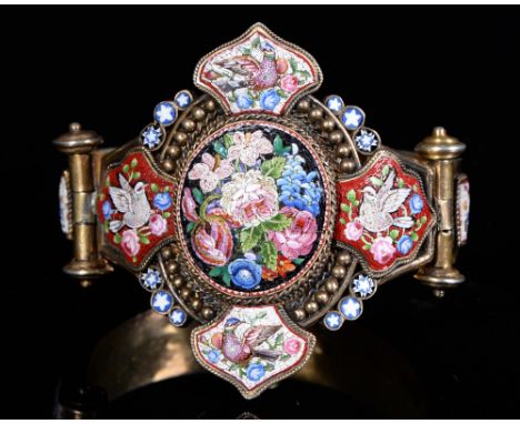 An Italian silver gilt and micro-mosaic bangle, 19th c, of three curved sections, that to the oval centre with tightly groupe
