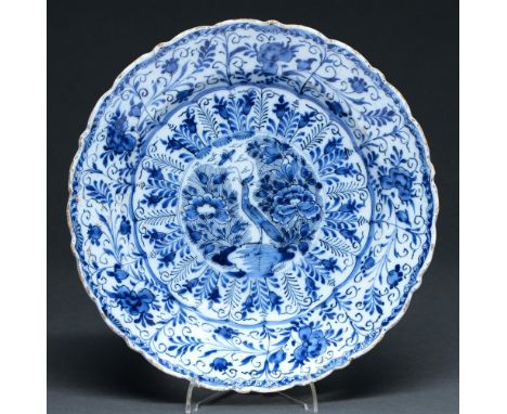 A Dutch Delftware dish, 18th c,&nbsp; painted in cobalt with a stylised bird flanked by peonies, in circular frame and panell