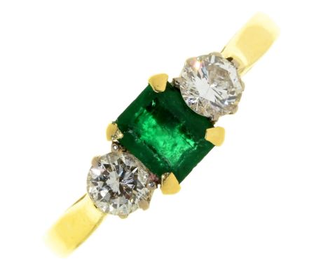 An emerald and diamond three stone ring, the step cut emerald flanked by evenly sized round brilliant cut diamonds, in 18ct g