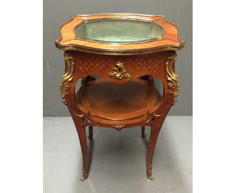 A 19TH CENTURY FRENCH KINGWOOD AND MARQUETRY INLAID BIJOUTERIE TABLE With rise and fall glazed top, above an open shelf, rais