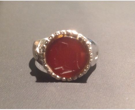 AN ANTIQUE 18CT GOLD RING Set with a Cornelian intaglio portrait of a Grecian warrior, stamped '750' (size S).