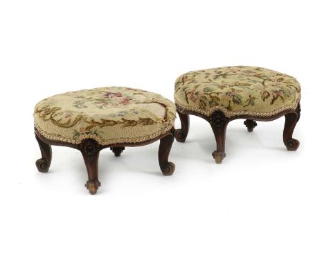 A pair of walnut Victorian stools,the oval tapestry seats, raised on foliate decorated cabriole supports,37cm wide,32cm deep,