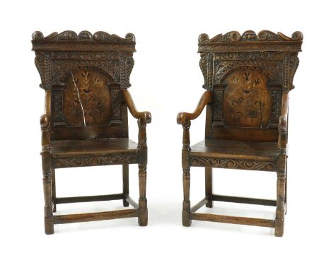 A pair of oak and inlaid wainscot chairs, probably 19th century but incorporating some earlier elements, each with a scrollin