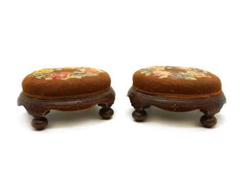 A pair of Victorian mahogany footstools, the oval tapestry foliate seats, raised on bun feet, 35cm wide, 29cm deep, 17cm high