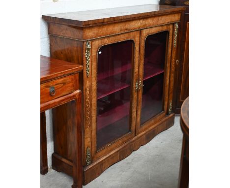 A 19th century rosewood, walnut and marquetry inlaid pier cabinet with ormolou mounts, the pair of glazed doors enclosing vel