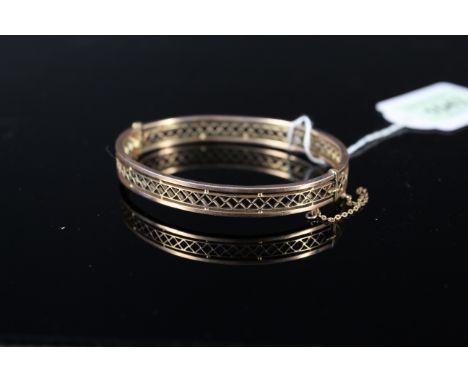 A 9ct gold pierced design bangle (small split noted), weight approx 11g