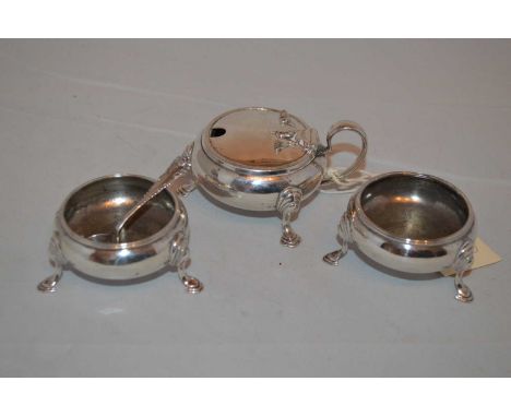 A three piece silver condiment set, by Haseler Brothers, London 1900, comprising two table salts and a mustard pot with blue 