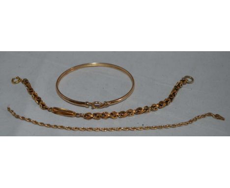 A selection of yellow metal jewellery, including: a fancy link bracelet stamped '9ct'; a bangle, unmarked; and a twist link b
