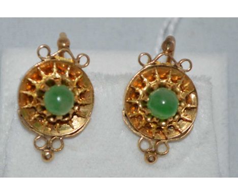 A green stone gold earrings, the green stone cabochons (probably jade), in yellow metal mounts, each stamped '14', 5.9g gross