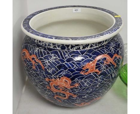 A Chinese blue and white planter, decorated with dragon figures in red, on a ground of blue stylized waves, approximately 40c