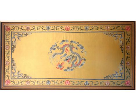 Chinese embroidery on silk depicting a central five-claw dragon chasing the flaming pearl, within a floral border, 91 x 43.7c