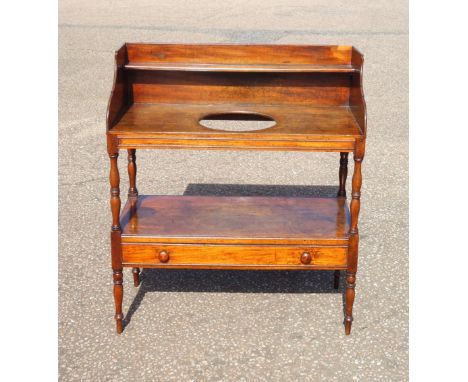 Victorian mahogany washstand with a shelf and circular aperture above, undertier and drawer below, on turned tapering legs, 1