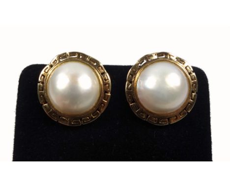 Pair of yellow metal clip on earrings set pearls, in a pierced surround, stamped 14k and 585, 7.0 grams 