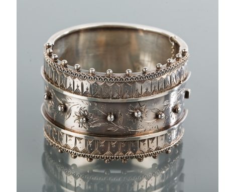 VICTORIAN SILVER BANGLE
with banded decoration, the central band with engraved floral motifs and with overlaid spheres, by Ha