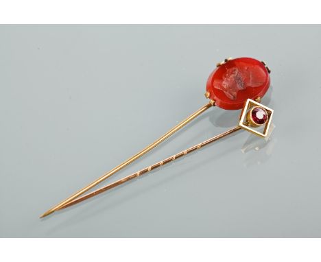 THREE EDWARDIAN TIE PINS
one set with a round garnet, unmarked, in a box; one set with a carved intaglio, in a box, unmarked 