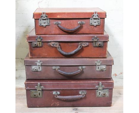 A stack of four vintage leather travel cases.  