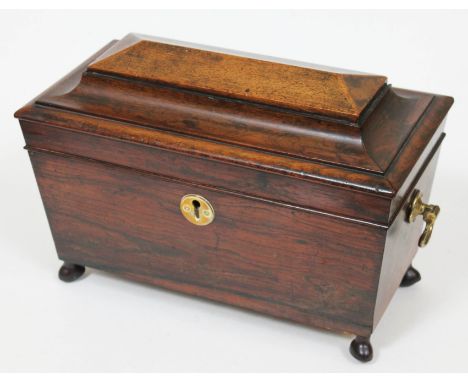 A Regency rosewood tea caddy of sarcophagus form with brass handles and later feet, length 39cm.  