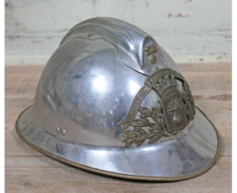 A French Fireman's helmet, chromed finish with brass bound brim and brass helmet plate embossed 'SAPEURS POMPIERS LEVOUEMENT'