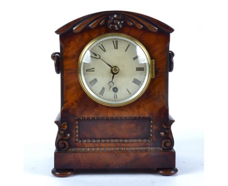 A William IV mahogany bracket clock, domed top with carved motifs standing on bun feet, white dial with Roman numeral, exhibi