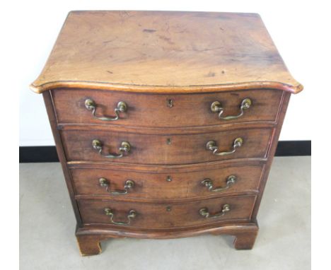 An antique mahogany serpentine chest, of four long drawers, shaped moulded top, brass carrying handle to either side and rais
