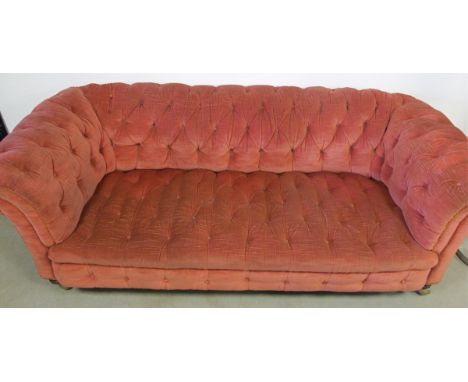 A button back Chesterfield sofa, upholstered in rose fabric, with gold braiding, with replacement castors, 200cm x 96cm