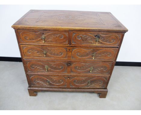 An 18th Century oak chest,  of two short over three long  graduated drawers, later carving to panelled sides, top and drawer 