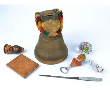 A Swiss cowbell together with two Black Forest collectables,  being a bottle opening in the form of a grinning old lady, and 