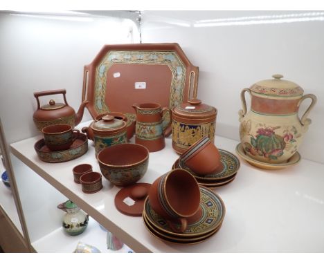 A TERRACOTTA PART TEA SERVICE IN EGYPTIAN TASTE brightly painted with figural scenes and geometric banding (on view at Fine A