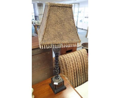 A CARVED WOODEN TABLE LAMP with ebonised and gilt leaf decoration (on view at Fine Art)