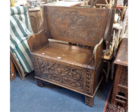 A CARVED OAK MONK'S BENCH