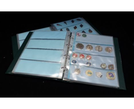 A COLLECTION OF ENAMEL PENDANTS contained in an album
