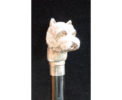 AN EBONISED WALKING STICK with a silver plated 'dog's head' terminal