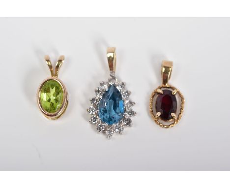 THREE PENDANTS, the first of 9ct gold set with an oval cut garnet within a rope twist surround, with 9ct hallmark for Birming