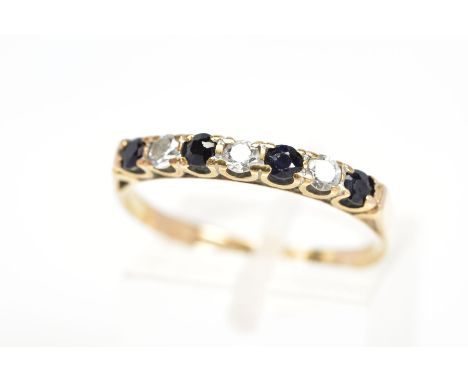 A 9CT GOLD SAPPHIRE AND CUBIC ZIRCONIA RING, designed as a line of four circular sapphires interspaced by colourless cubic zi