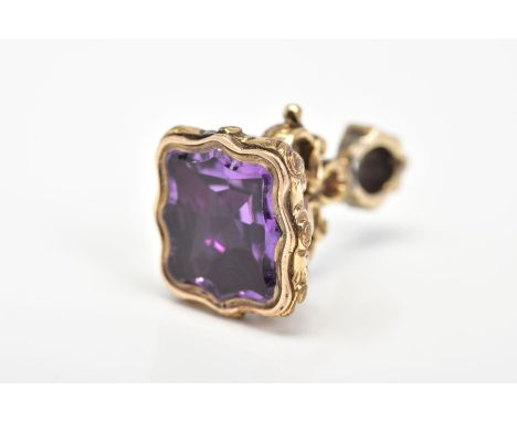 A FOB, set with a shaped amethyst panel, with scroll design grip, length 25mm
