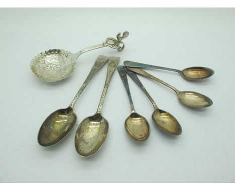 A Continental Caddy Spoon, (indistinctly stamped), with scroll hook handle, detailed in relief with figures with rural dwelli