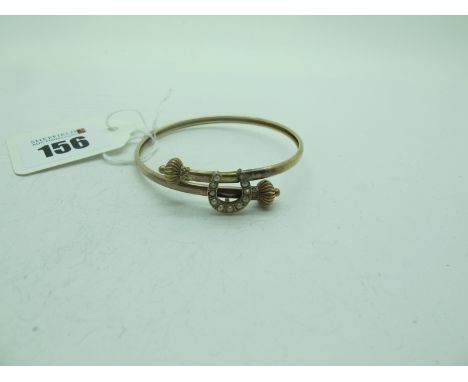 An Edwardian Pearl Set Horseshoe Bangle, of crossover design. 
